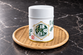 Tamahime no Shiro matcha 20 g tin on a woven bamboo tray with a dark marble background